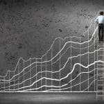 Image of a man on a ladder working on a chart to better his small business bottom line