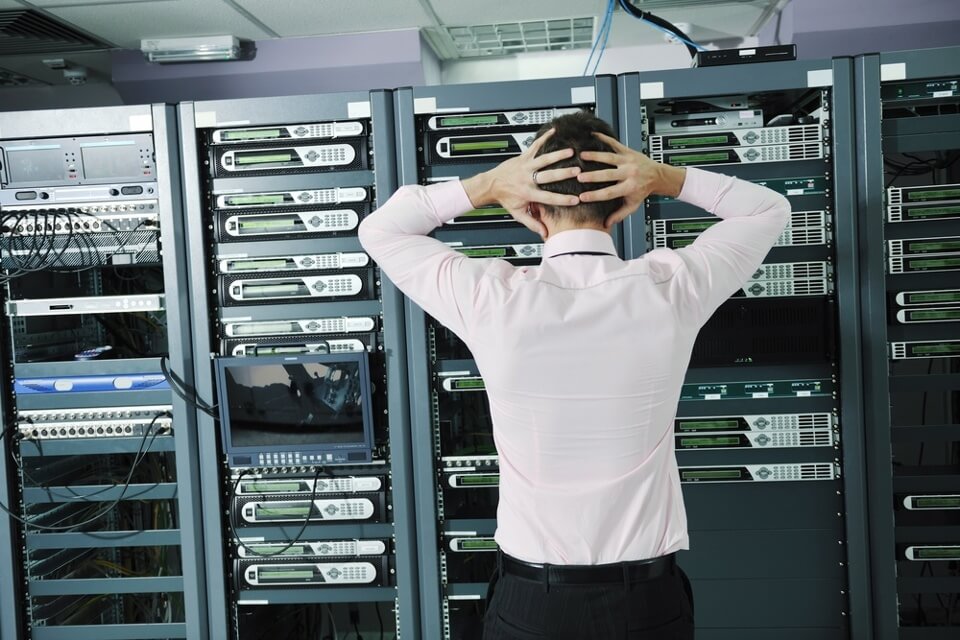 Image of a man in a server room thinking about his disaster recovery plan